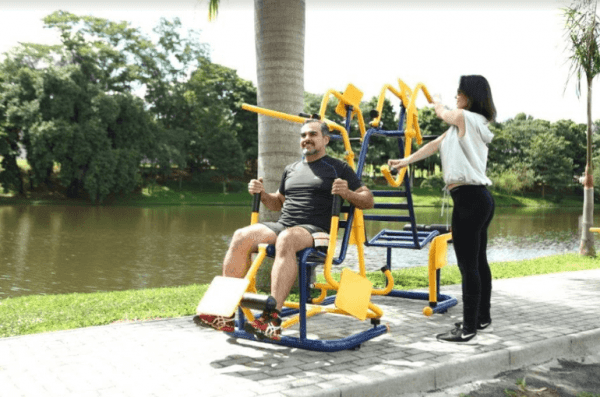 homem e mulher fazendo exercícios em aparelhos de academia ao ar livre
